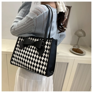 Vue lifestyle d'un sac cabas à carreaux avec nœud porté à l'épaule par un mannequin