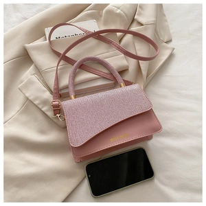 Pink lady's mini handbag with textured flap and leather body next to smartphone for size