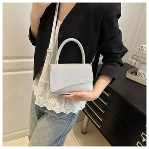 Detail of silver sequined handbag with miss.mini lettering and a hard top handle