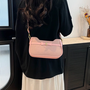 Chique roze schoudertas met kattenoorsilhouet en strikdetail getoond op vrouwelijk model