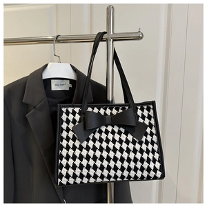 Détail du sac cabas à motif pied-de-poule avec grand nœud noir et anse en similicuir