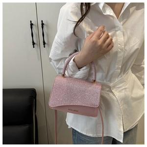 Detail of pink sequin mini handbag with brand logo and golden metal hardware