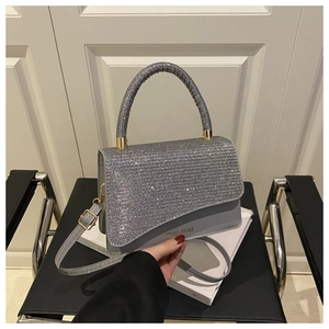 Macro view of grey handbag with sparkling glitter flap and miss.mini logo branding