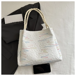 Détail du cabas blanc avec broderie multicolore et poignée en corde tressée élégante