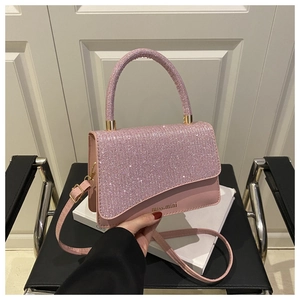 Detail of pink sequin handbag showing the miss.mini logo and gold-tone metal hardware