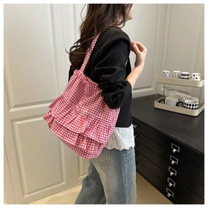 Détail de face latérale d'un sac cabas à carreaux rose et blanc avec trois couches de volants