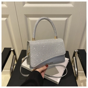 Detailed view of silver sequined handbag with miss.mini logo and metallic chain strap