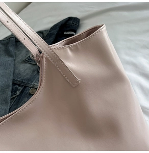 Detail of pink faux leather tote bag showing high-quality stitching on shoulder straps