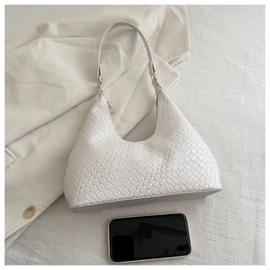 Detail of white woven textured hobo bag featuring premium gold hardware and smooth curved design