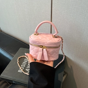 Detailed view of pink quilted box bag with gold double zippers and chain strap