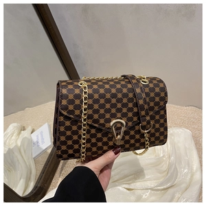 Détail d'un sac porté épaule vintage marron avec chaîne dorée et fermoir fer à cheval