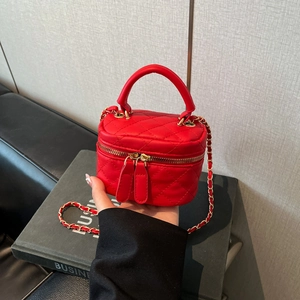 Macro detail of red quilted box bag with gold chain strap and dual zippers