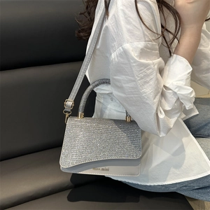 Silver shoulder bag with shimmering crystals and miss.mini logo on a white shirt model