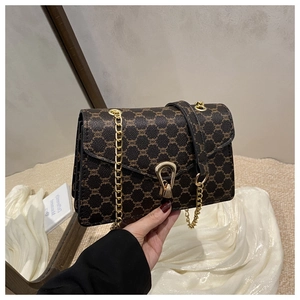 Détail du sac rétro avec chaîne dorée et fermoir en U sur cuir à motifs géométriques