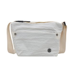 White minimalist crossbody bag with crinkle texture and wide strap on white backdrop