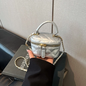 Close-up of silver quilted micro box bag with metallic texture and gold chain strap