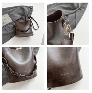 Detail view of dark brown bucket bag featuring braided handle and polished gold hardware