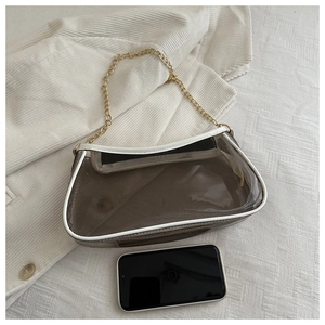 Détail du sac chaîne en PVC gris avec bordure blanche et smartphone pour comparer la taille