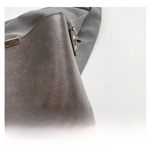 Macro view of vintage dark brown matte leather texture and stitching detail on bucket bag