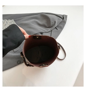Close-up of brown leather bucket bag interior showing magnetic clasp and large capacity