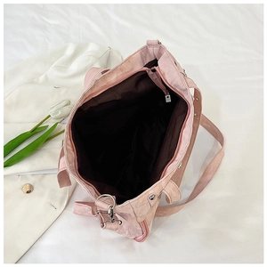 Macro view of a large pink tote bag featuring a secure zipper closure and spacious interior