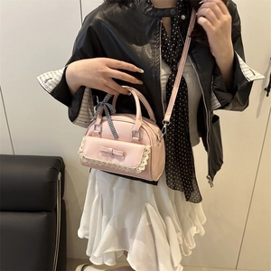Pink crossbody handbag with lace trim and bow detail shown on a model for a sweet look