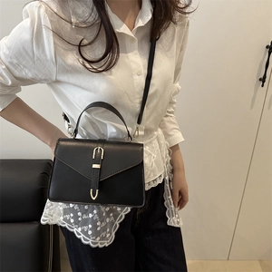 Minimalist black trapezoid crossbody bag with gold buckle and top handle for women