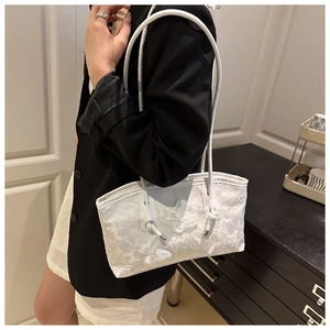 Vue détaillée d'un sac en dentelle blanche avec broderies papillons 3D et fine anse