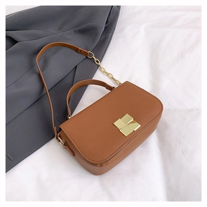 Detail of a brown leather shoulder bag featuring a gold buckle and chain strap