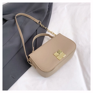 Detail of beige leather square bag with gold geometric buckle and chain strap