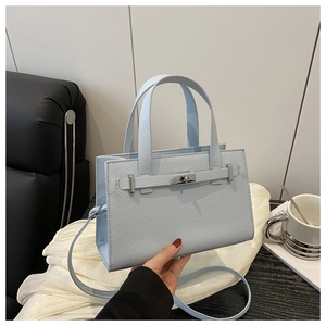 Detail of light blue pebble leather handbag with silver metallic turn-lock and strap