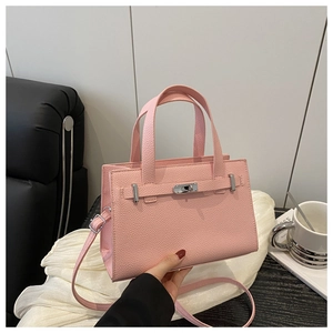 Detailed shot of pink pebble leather handbag with silver turn-lock and elegant handle