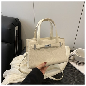 Detail of cream lychee textured leather tote with silver metal twist lock closure