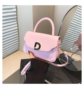 Détail d'un mini sac à main rose clair avec boucle en D et bandoulière amovible