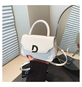 Détail d'un sac à main en cuir blanc avec boucle en D dorée et poignée supérieure chic