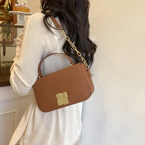 Caramel brown leather crossbody bag with iconic gold square clasp shown on model