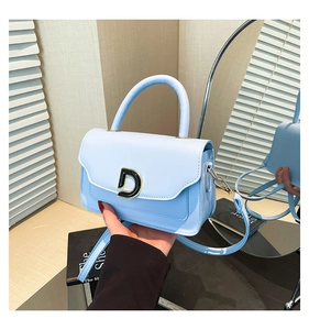 Détail du sac bandoulière bleu clair avec boucle en D métallique et finition brillante