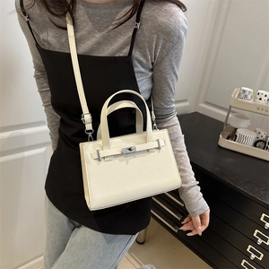 Chic off-white lychee texture handbag with metal clasp lock shown on a female model