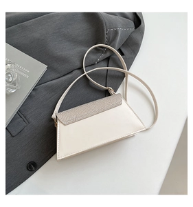 Detail view of the asymmetric trapezoid crossbody bag with a glitter texture flap cover