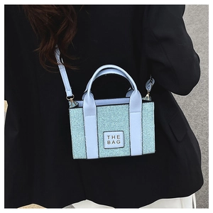 Detailansicht der minzblauen Mini-Tote-Bag mit THE BAG Aufnäher und Textur-Gewebe