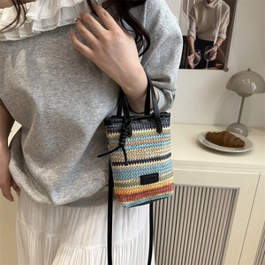 Chic multi-color striped woven bucket bag with leather handles and fashion label detail