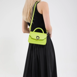 Mini sac bandoulière en cuir vert fluo avec boucle D argentée porté par un mannequin