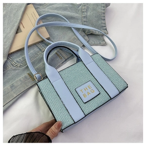 Detail der hellblauen gewebten Tote Bag mit Ledergriffen und goldener Aufschrift