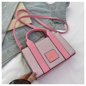 Detailaufnahme der rosa gewebten Tragetasche mit Lederaufnäher und THE BAG Text