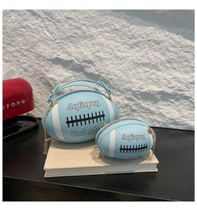 Nahaufnahme der blauen Rugby-Umhängetaschen mit Goldketten und weißen Streifendetails
