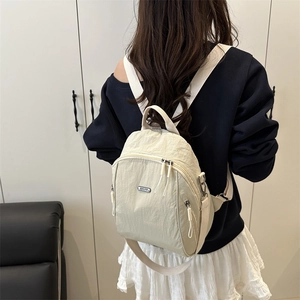 Mini zaino bianco crema in tessuto stropicciato indossato da una modella vista da dietro