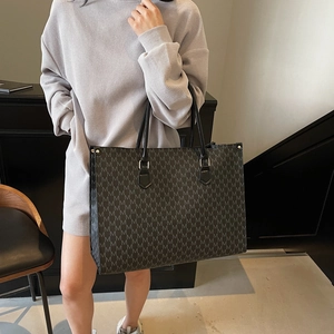 Black monogram M tote bag with large capacity for women shown in a casual lifestyle setting
