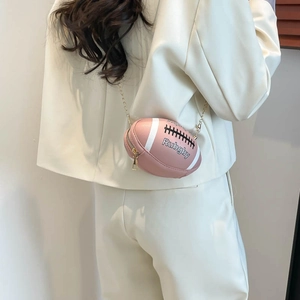 Rosa Rugby-Umhängetasche mit goldener Kette an der Schulter des Models gezeigt