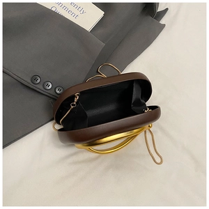 Detail of dark brown capsule evening bag with gold ring handle and chain strap