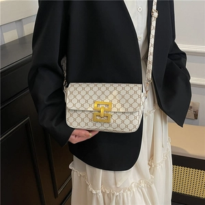 Retro beige crossbody bag with chain print and gold buckle on a stylish model